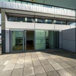 Property for sale by Auction A spacious balcony with a cement floor offers views of the city. Glass doors and windows lead to the interior of a modern Liverpool penthouse investment apartment. Metal and glass structures surround the area, providing a sleek and contemporary feel. The sky is clear in the background. Presented by World of Auctions
