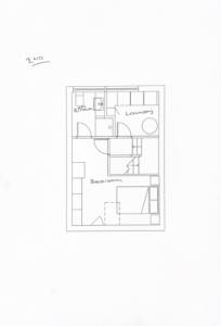 Line drawing of a floor plan labeled “2ND.” The layout includes a bedroom with a bed and a desk, a bathroom with fixtures, and a laundry room with a washing machine. Arrows indicate doors and pathways between rooms.
