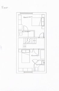 This black and white floor plan depicts the layout of the first floor. It includes two bedrooms, two bathrooms, and a staircase. The bedrooms and bathrooms are labeled for easy identification. The rooms are arranged linearly with a corridor connecting them.
