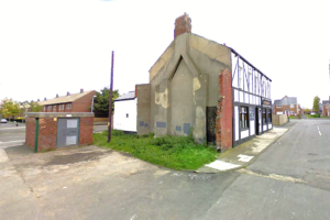 Property for sale by Auction A deteriorating former public house in Jarrow, Tyne and Wear stands at a street corner, with partially missing walls and visible structural damage. The facade shows exposed wooden beams and a significant amount of chipped plaster. Adjacent to it is a small, bricked utility structure. Presented by World of Auctions