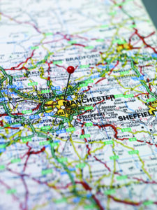 Property for sale by Auction A detailed map of part of England with a red pin marking the city of Manchester. Surrounding cities like Bradford, Huddersfield, and Sheffield are also visible. Various roads, highways, towns, and geographic features are intricately depicted. Presented by World of Auctions
