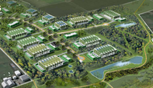 Property for sale by Auction Aerial view of a sprawling industrial complex with multiple green-roofed buildings surrounded by lush greenery, ponds, and landscaped areas. Roads and pathways connect the buildings, and there are solar panels on some rooftops. The complex is bordered by forests and fields. Presented by World of Auctions